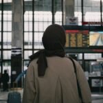 Muslim woman traveler with luggage at a transit terminal