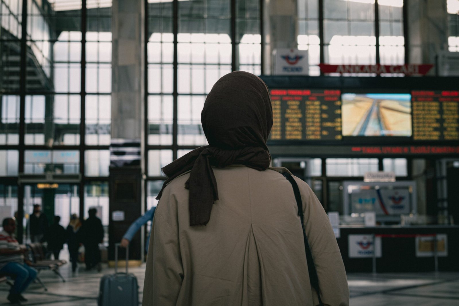 Muslim woman traveler with luggage at a transit terminal
